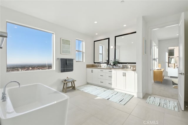 bathroom with a tub to relax in, vanity, tile patterned flooring, and radiator heating unit