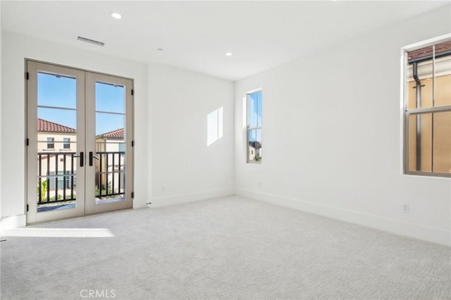 carpeted empty room featuring french doors