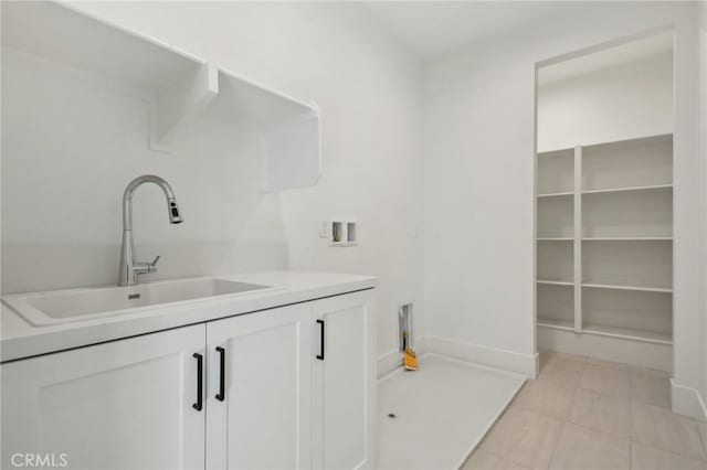 washroom featuring cabinets, light tile patterned flooring, hookup for a washing machine, and sink