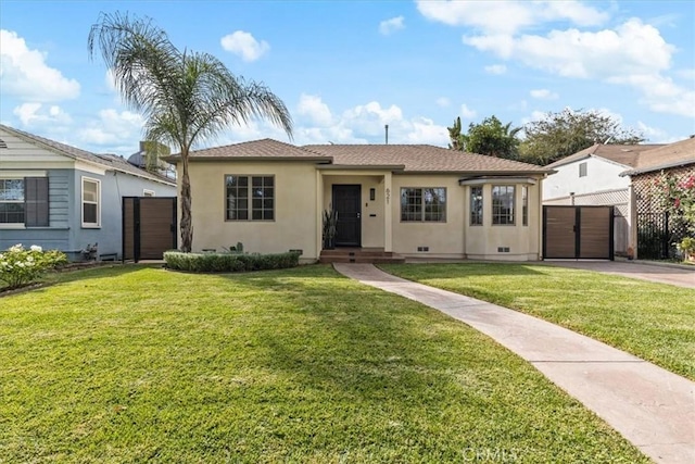 ranch-style house with driveway, a front yard, fence, and stucco siding