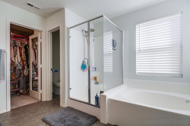 bathroom featuring toilet, tile patterned floors, and separate shower and tub