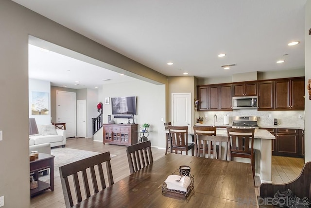 dining space featuring sink and light hardwood / wood-style flooring