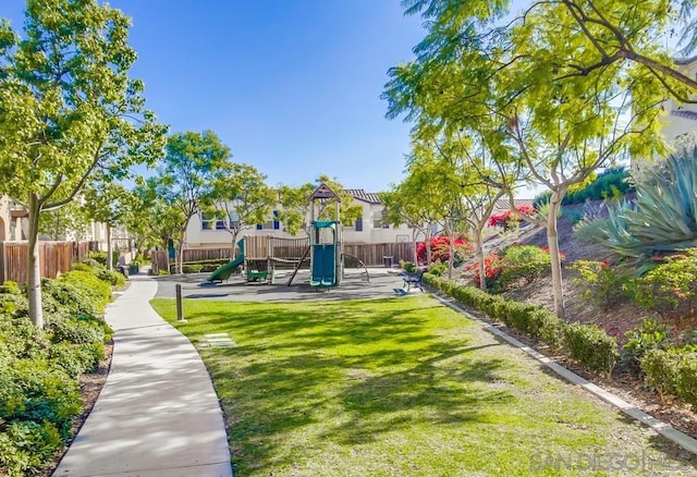 view of home's community featuring a playground and a lawn