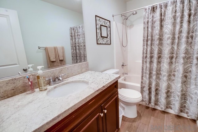 full bathroom featuring toilet, vanity, shower / bath combo with shower curtain, and hardwood / wood-style flooring