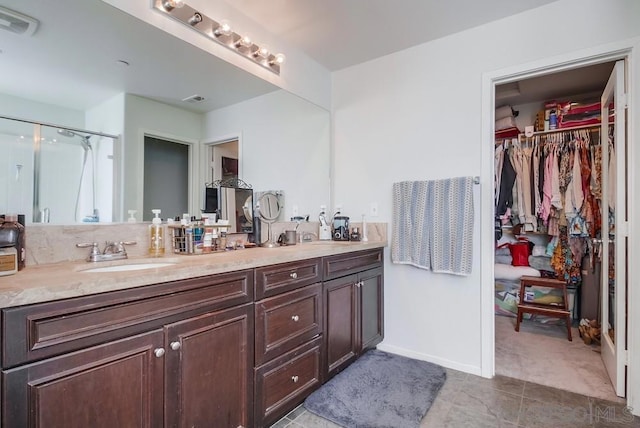 bathroom with vanity and a shower with door