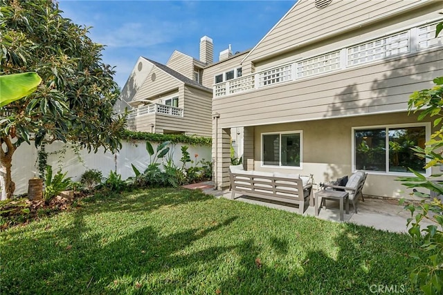 rear view of property with a patio area, an outdoor living space, a lawn, and a balcony