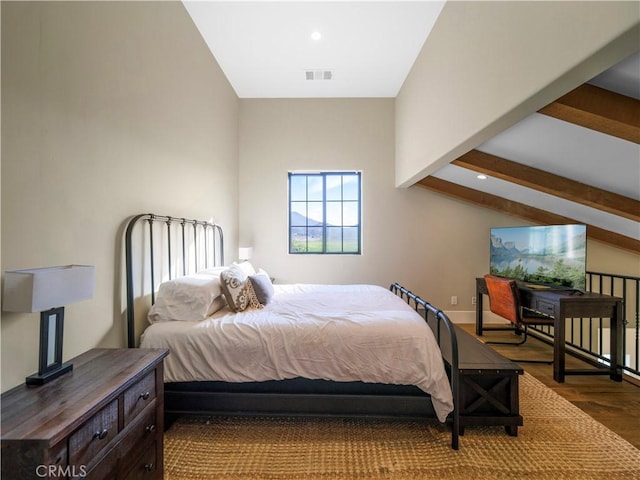 bedroom featuring vaulted ceiling with beams and hardwood / wood-style flooring