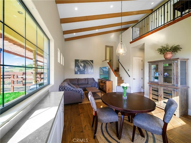 dining room featuring dark wood-type flooring, beam ceiling, and high vaulted ceiling