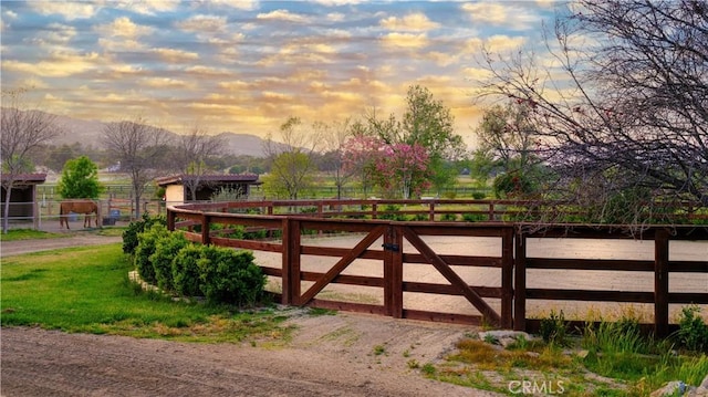 gate at dusk with a rural view and a mountain view