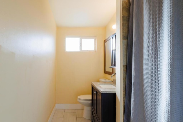 bathroom with toilet, vanity, and walk in shower