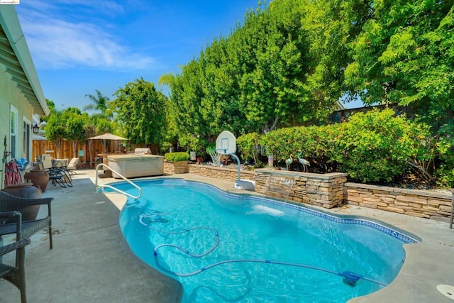 view of pool with a hot tub and a patio