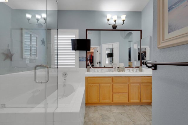 bathroom featuring vanity, a notable chandelier, and shower with separate bathtub