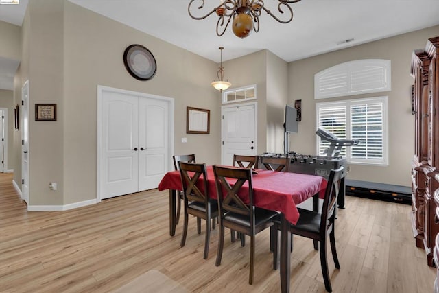 dining room featuring light wood-type flooring and a chandelier