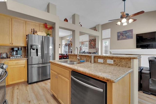 kitchen featuring light brown cabinetry, sink, stainless steel appliances, and light hardwood / wood-style flooring