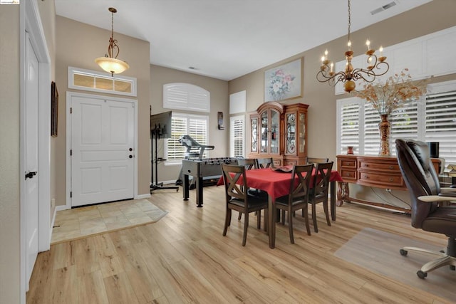 dining space with a chandelier and light wood-type flooring