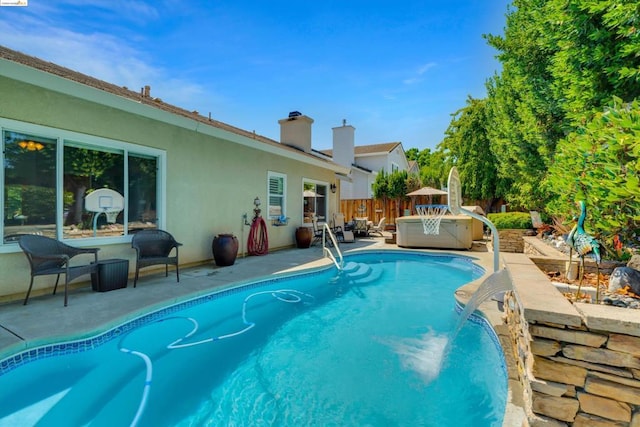 view of swimming pool with a hot tub and a patio