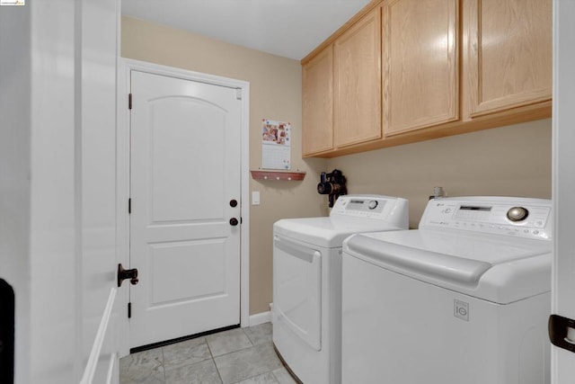 clothes washing area with cabinets, independent washer and dryer, and light tile patterned flooring