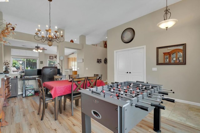 rec room featuring ceiling fan with notable chandelier and light wood-type flooring