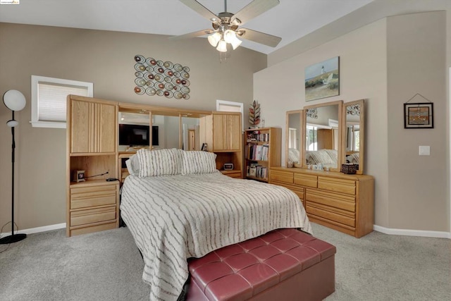 bedroom with ceiling fan, light carpet, and vaulted ceiling