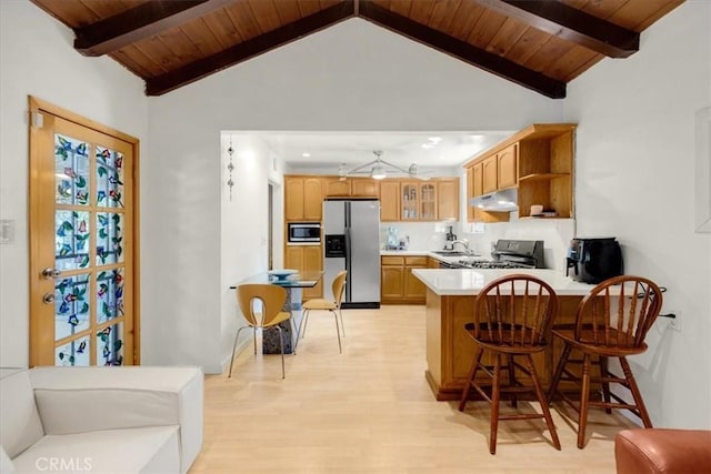 kitchen with lofted ceiling with beams, appliances with stainless steel finishes, a breakfast bar, and light hardwood / wood-style floors