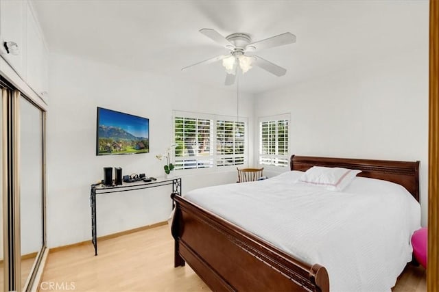 bedroom with light hardwood / wood-style floors, a closet, and ceiling fan