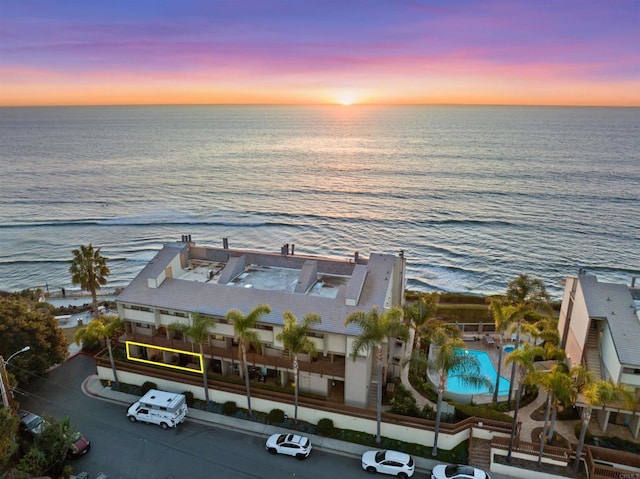 aerial view at dusk featuring a water view