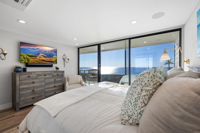 bedroom featuring access to exterior, floor to ceiling windows, and hardwood / wood-style floors