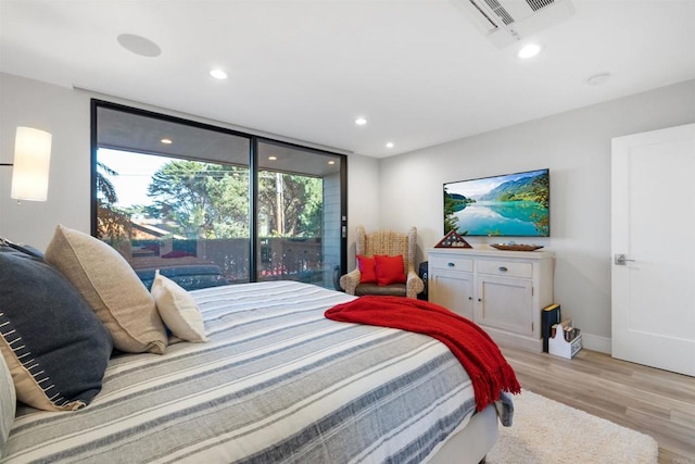 bedroom featuring floor to ceiling windows and light hardwood / wood-style flooring