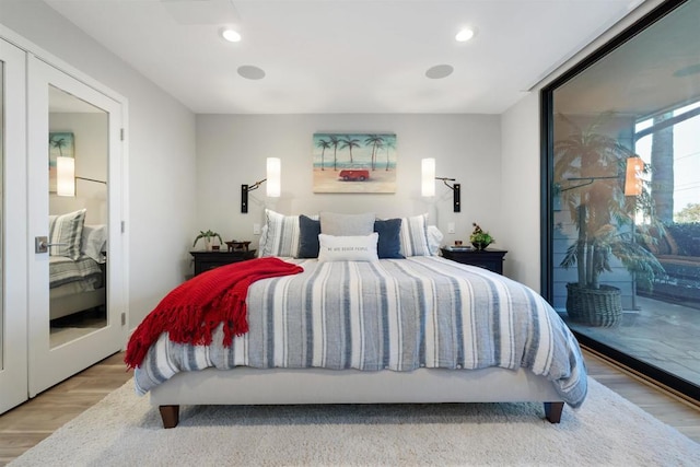 bedroom with access to exterior and light hardwood / wood-style flooring