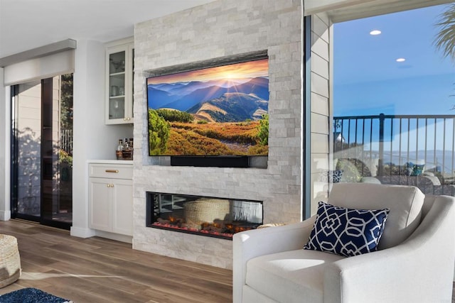 sitting room with dark hardwood / wood-style floors and a stone fireplace