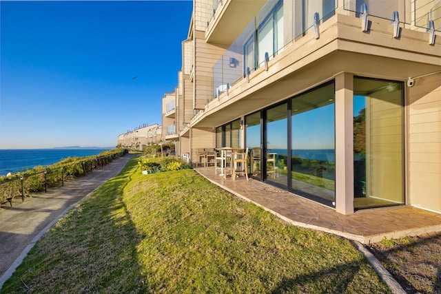 view of yard featuring a water view and a patio