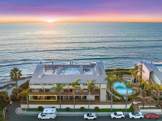 aerial view at dusk featuring a water view