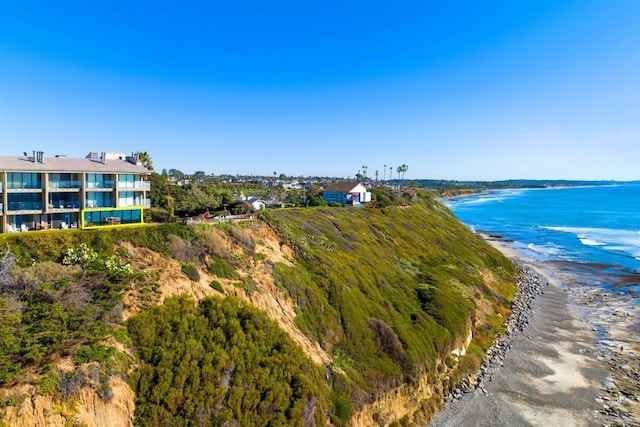 birds eye view of property with a water view and a beach view