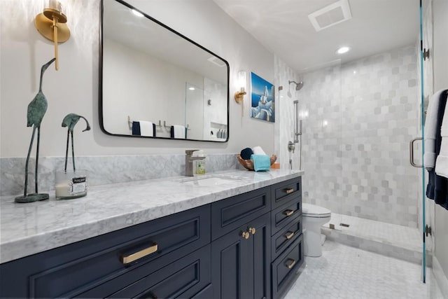 bathroom with toilet, vanity, a shower with door, and tile patterned floors