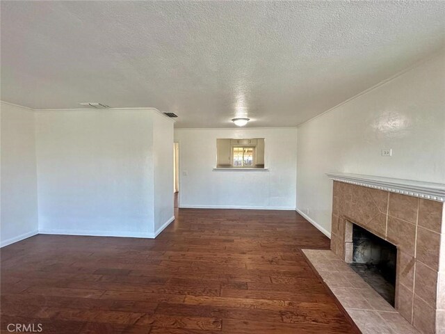 unfurnished living room with a tile fireplace, a textured ceiling, and hardwood / wood-style flooring