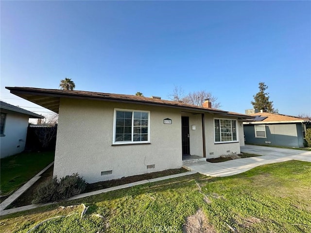 ranch-style home with a chimney, crawl space, a front yard, and stucco siding