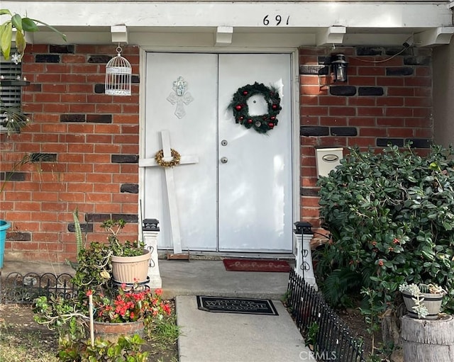 doorway to property with brick siding