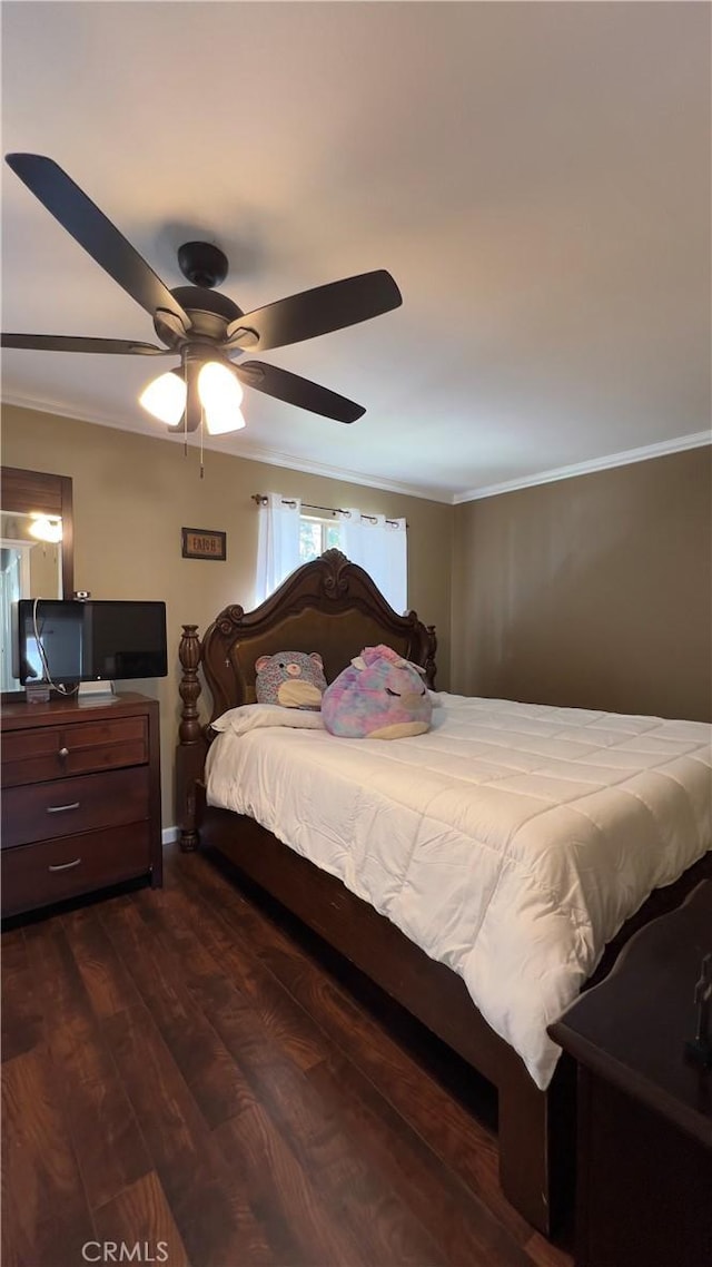 bedroom with ornamental molding, dark wood-style flooring, and a ceiling fan