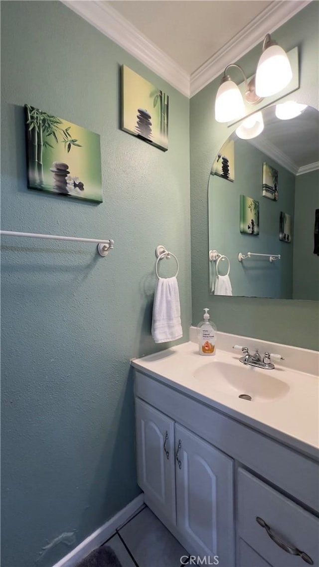 bathroom featuring tile patterned flooring, crown molding, and vanity