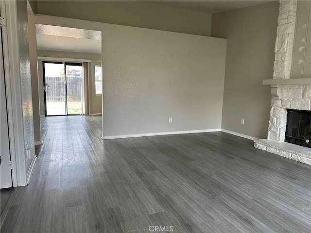 unfurnished living room with dark wood-type flooring and a fireplace