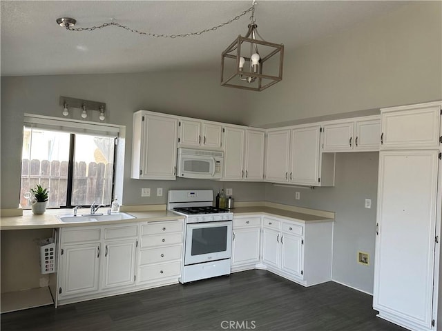 kitchen with sink, white cabinets, hanging light fixtures, and white appliances