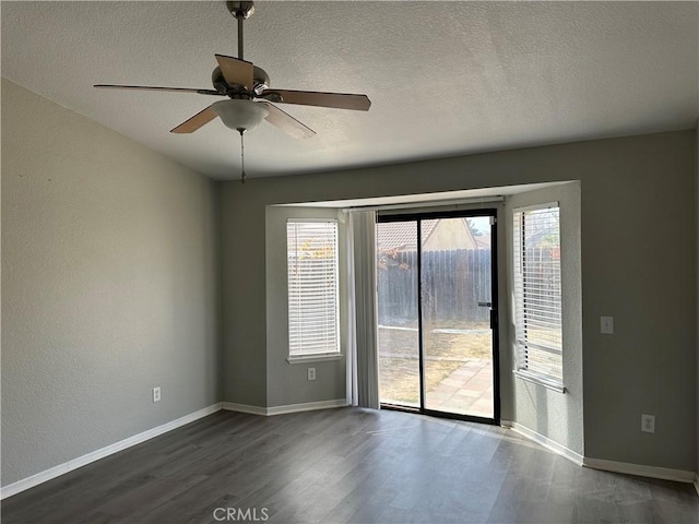 spare room featuring ceiling fan, a textured ceiling, and dark hardwood / wood-style floors