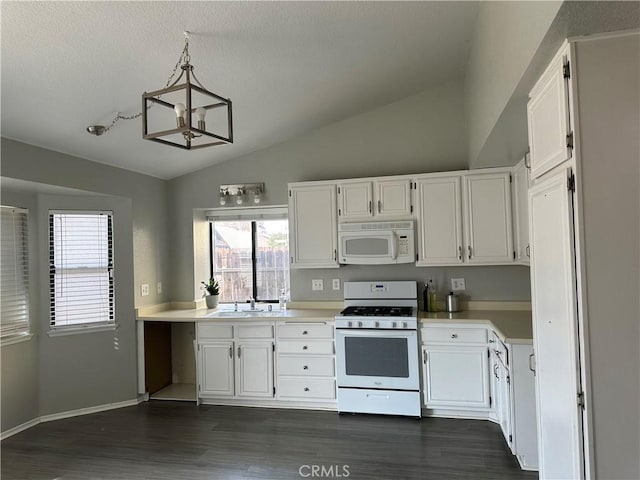 kitchen featuring white appliances, hanging light fixtures, vaulted ceiling, white cabinets, and sink