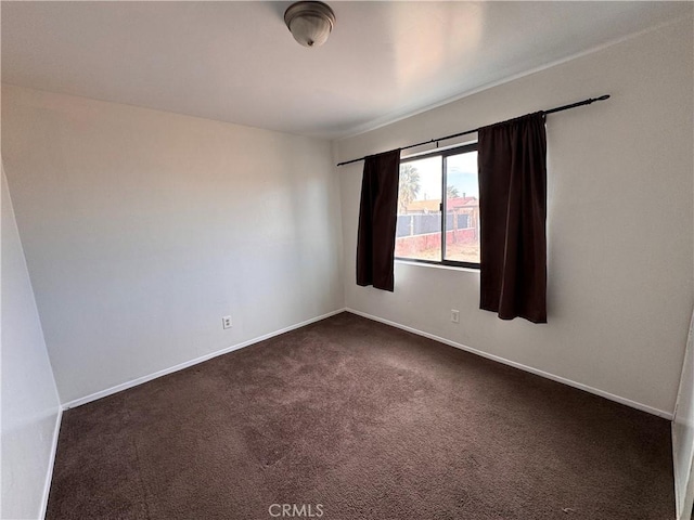 spare room featuring dark colored carpet