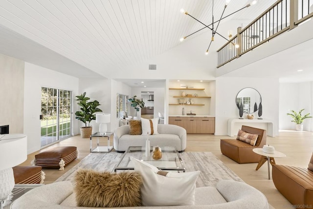 living room with light wood-type flooring, a towering ceiling, an inviting chandelier, and wooden ceiling