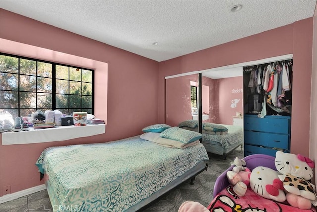 bedroom with a textured ceiling and a closet