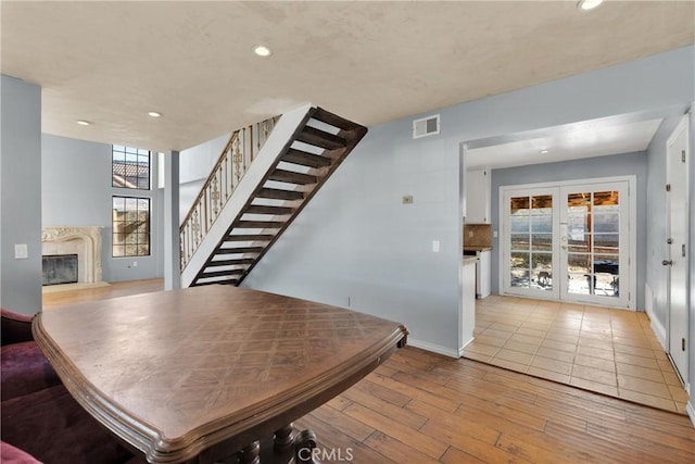 dining space with french doors and light hardwood / wood-style flooring