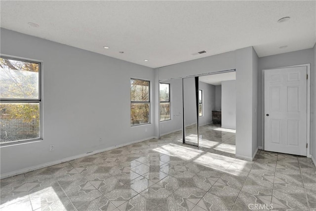 unfurnished bedroom featuring multiple windows and a closet