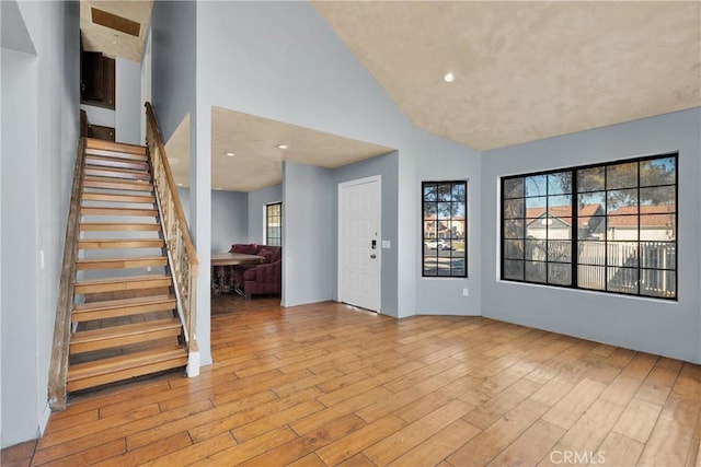 entryway featuring high vaulted ceiling and light hardwood / wood-style floors