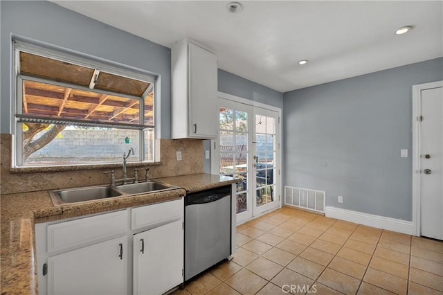 kitchen featuring dishwasher, decorative backsplash, sink, light tile patterned flooring, and white cabinetry